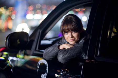 Emma Stone looks out of a dark jeep.