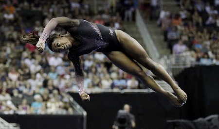 Simone Biles performing a double-twisting, double somersault dismount.