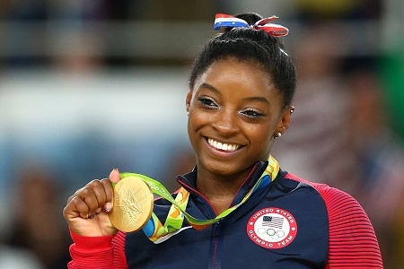 Biles holding a gold medal at the Rio 2016 Olympics.