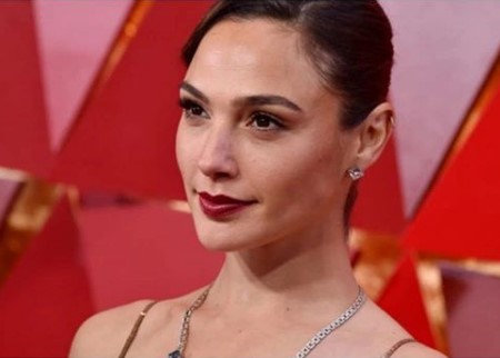 Gal Gadot wearing a diamond earings and a necklace.