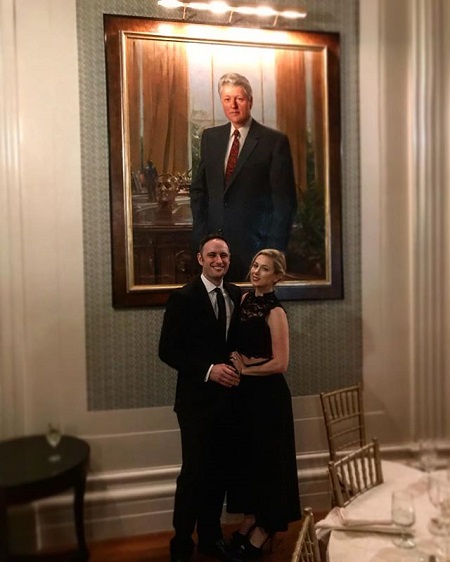 Iliza and Noah at the Yale Club of New York City for a party. A picture of George Bush in the background.