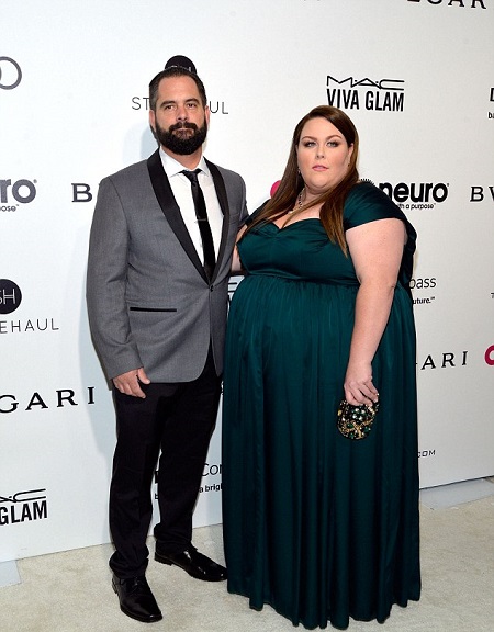 Josh Stancil (left) in a suit standing beside Chrissy (right) in her green dress.