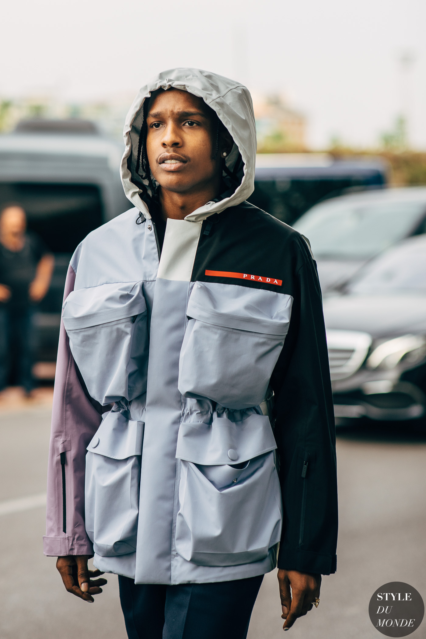 asap rocky wearing a grey and black jacket strutting on the street 