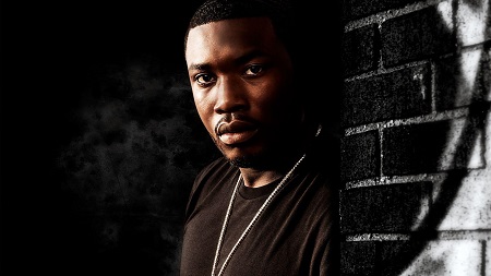 Meek Mill edited photo leaning against the wall.