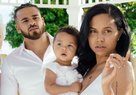 Cheyenne Floyd holding their daughter, Ryder, as Cory Wharton is behind her. All wearing white.