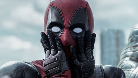 Deadpool is amazed by something he sees off screen and puts both his palms on his cheeks.