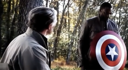 Sam holds Captain America's shield as Steve sits on a bench.