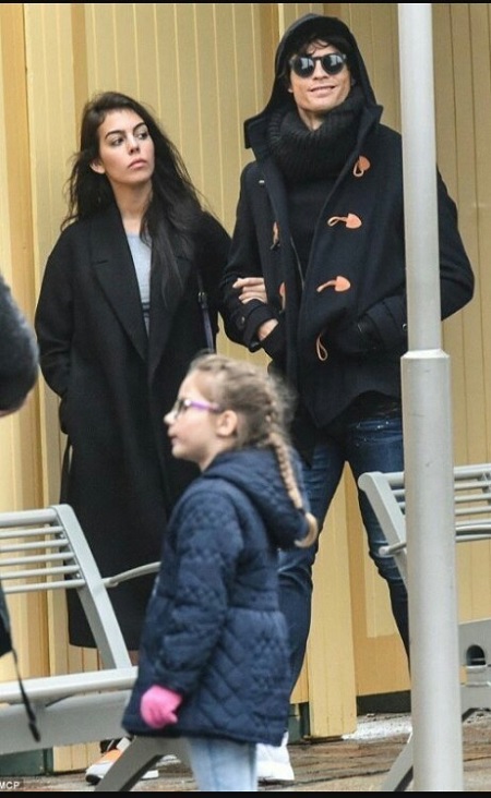 Cristiano Ronaldo in his disguise and smiling while walking with girlfriend Georgina Rodriguez during the date to Disneyland.