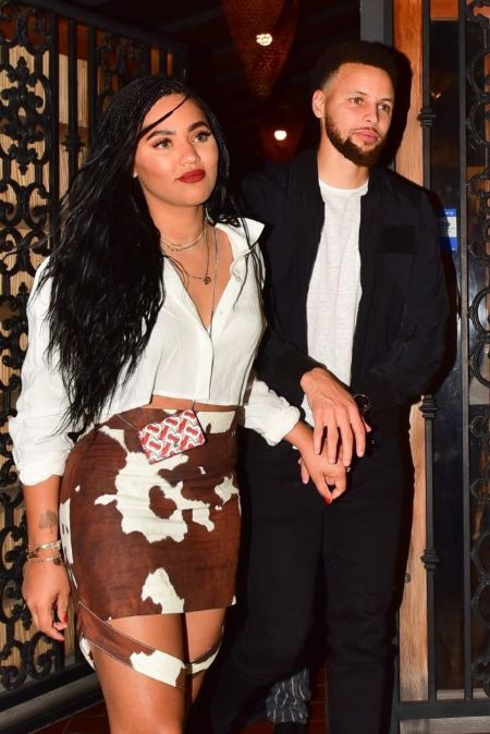 Steph holding his wife hand while walking out the restaurant.