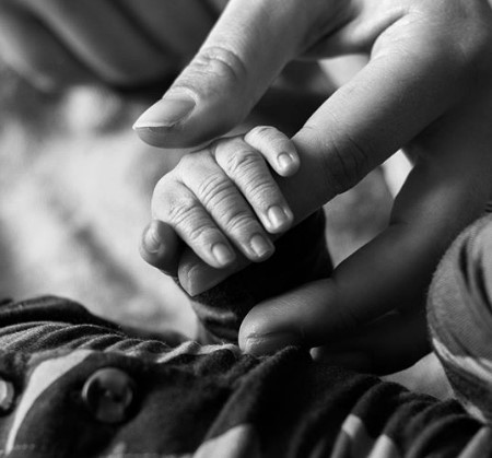 Ashley Graham's recent first born holds his mother's hands.