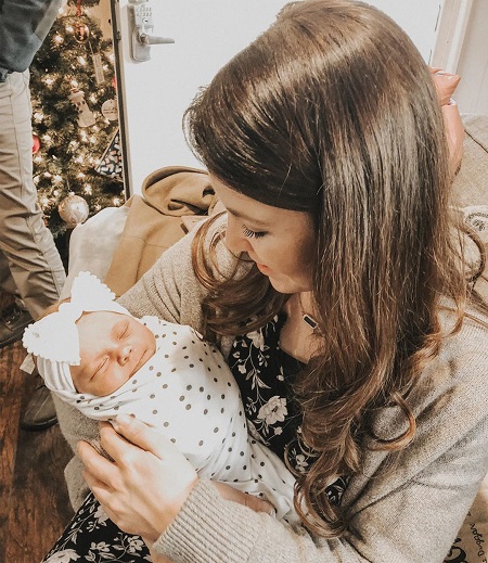 Jana Duggar holding John and Abbie Duggar's daughter.