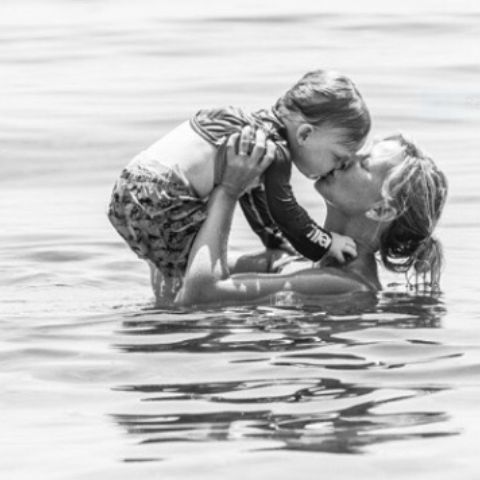 Kelli Giddish with her child in a swimming pool.